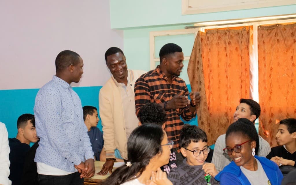 Facilitators engaging with attentive students during a classroom mentorship workshop session